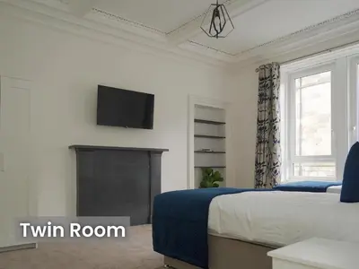 a bedroom with a bed and a tv on the wall at Edinburgh Modern Apartment in Haymarket, city centre in Edinburgh
