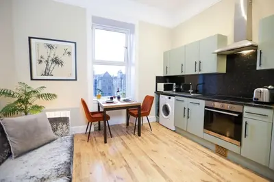 a kitchen with a table and chairs in a room at Cosy City Centre Gem in Edinburgh