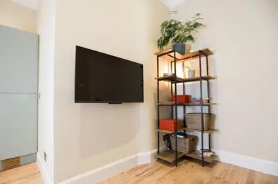 a flat screen tv hanging on a wall at Cosy City Centre Gem in Edinburgh