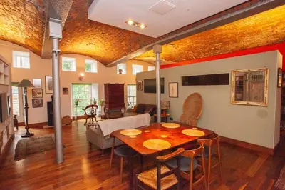 a living room with a wooden table and a couch at Unique House in Park District in Glasgow