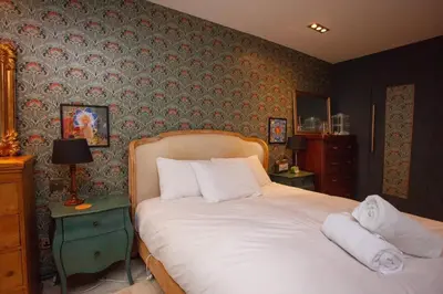 a bedroom with a large bed with white pillows at Unique House in Park District in Glasgow