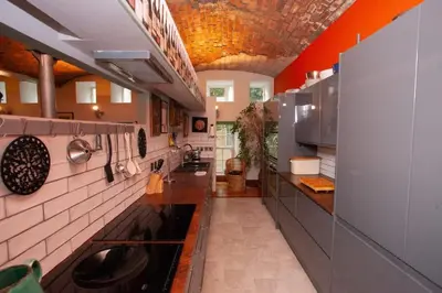 a large kitchen with red walls and white tiles at Unique House in Park District in Glasgow