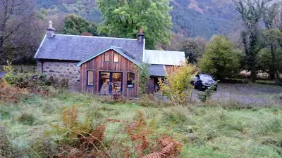 a house with a car parked in front of it at Red Deer Cottage at Fanans in Oban
