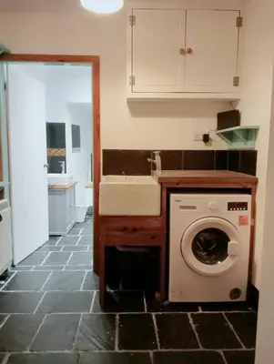 a kitchen with a washing machine and a sink at Red Deer Cottage at Fanans in Oban