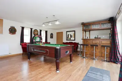 a living room with a pool table in it at JOIVY Greenknowes Farmhouse with Hot Tub and Bar in Kelty