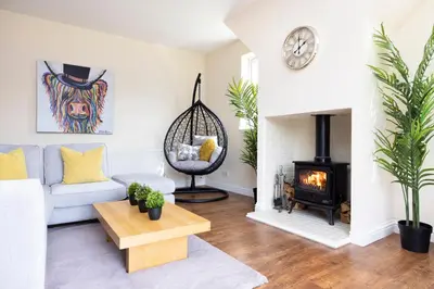 a living room with a couch and a fireplace at JOIVY Greenknowes Cottage with Hot Tub & Fireplace in Kelty