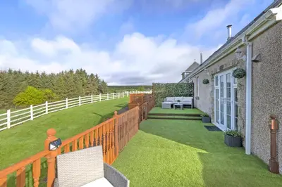 a balcony of a house with a fence at JOIVY Greenknowes Cottage with Hot Tub & Fireplace in Kelty