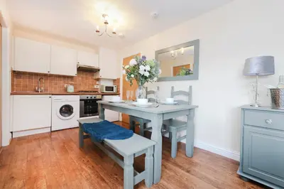 a kitchen with a table with a vase of flowers at JOIVY Greenknowes Lodge with Hot Tub and Wood Burning Stove in Kelty