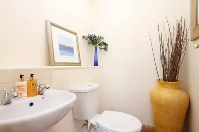 a bathroom with a sink and a toilet and a vase at JOIVY Greenknowes Estate with Hot Tub and Bar - Farmhouse and Lodge in Kelty