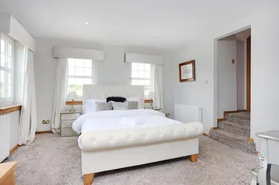 a white bedroom with a white bed and windows at JOIVY Greenknowes Estate with Hot Tub and Bar - Farmhouse and Lodge in Kelty