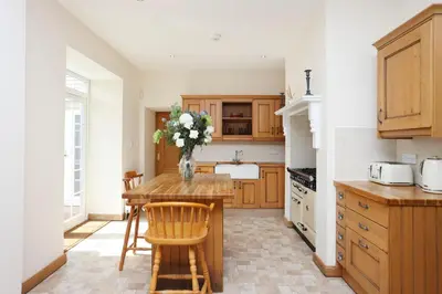 a kitchen with a table with a vase of flowers on it at JOIVY Greenknowes Estate with Hot Tub and Bar - Farmhouse and Lodge in Kelty