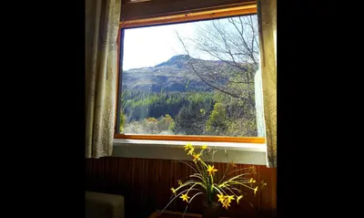 a window with a view of a mountain at An Carraig Log Cabin in Strathyre