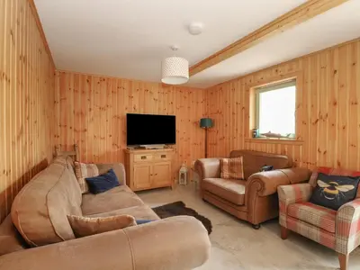 a living room with two couches and a flat screen tv at Bradan Lodge in Dalmally