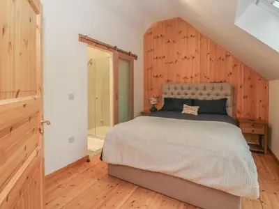 a bedroom with a bed with a wooden wall at Bradan Lodge in Dalmally