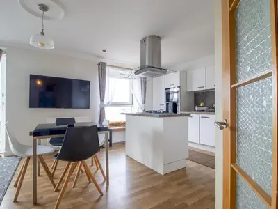 a kitchen and dining room with a table and chairs at Metropolitan St Andrews Cathedral View - Pass the Keys in Glasgow