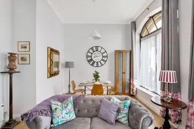 a living room with a couch and a clock on the wall at Alloa City Centre in Alloa