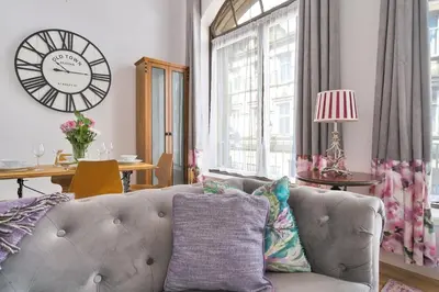 a living room with a couch and a clock on the wall at Alloa City Centre in Alloa