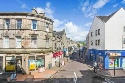 an empty street in a city with buildings at Alloa City Centre in Alloa