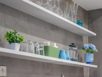 a shelf with glasses and vases on it in a kitchen at Fabulous Festival Park Home Private Parking Garden - Pass the Keys in Glasgow