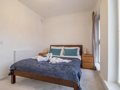 a bedroom with a bed with two people laying on it at Fabulous Festival Park Home Private Parking Garden - Pass the Keys in Glasgow
