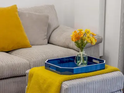 a vase of flowers sitting on a table next to a couch at Fabulous Festival Park Home Private Parking Garden - Pass the Keys in Glasgow