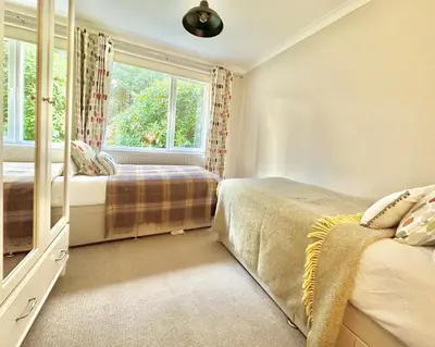 a bedroom with two beds and a window at Cherry Trees in Inveraray