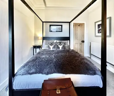 a bedroom with a large bed with a black frame at Cherry Trees in Inveraray