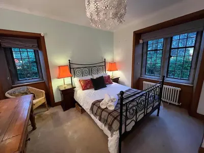 a bedroom with a bed and a chandelier at Lovely Carlung House in West Kilbride