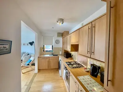 a kitchen with wooden cabinets and a stove top oven at Perfect Location in Heart of Glasgow West End - Pass the Keys in Glasgow