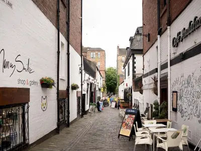 an alley with tables and chairs on a street at Perfect Location in Heart of Glasgow West End - Pass the Keys in Glasgow