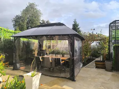 a black gazebo with a table in a garden at Modern Oasis , Edinburgh Airport near,8mi in Rosyth