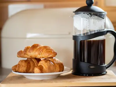 a coffee maker with croissants and a plate of croissants at Chalet Loch Leven Lodge 21 by Interhome in Kinross