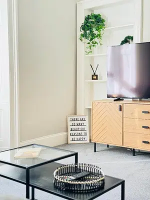 a living room with a glass table and a tv at Elegant City Centre Apartment in Edinburgh
