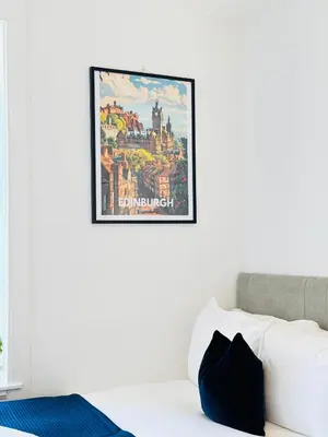 a picture hanging on a wall above a bed at Elegant City Centre Apartment in Edinburgh