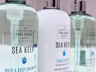 three bottles of sea kelp and soap on a shelf at Elegant City Centre Apartment in Edinburgh