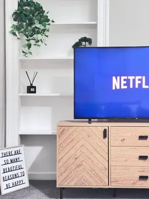 a tv sitting on top of a wooden dresser at Elegant City Centre Apartment in Edinburgh
