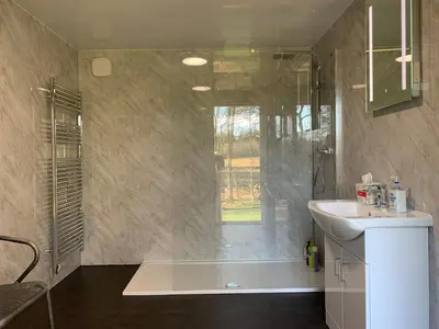 a bathroom with a tub and a sink and a shower at North Lodge Glamping in Carnwath