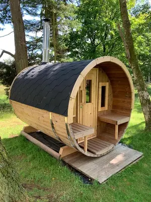 a large wooden hobbit house with a black roof at North Lodge Glamping in Carnwath