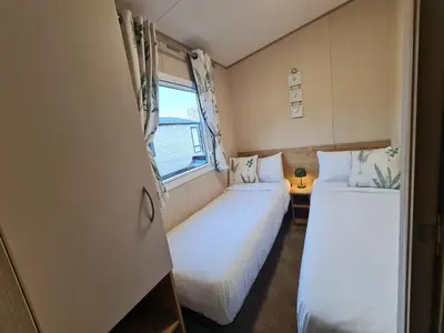 two beds in a small room with a window at 5 lochview in Beattock