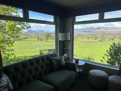 a living room with a couch and a large window at Ardenvhor - Loch Lomond in Gartocharn