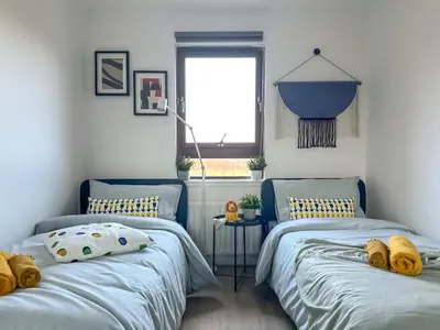 two twin beds in a room with a window at Cosy stylish Duntocher flat near Glasgow in Clydebank