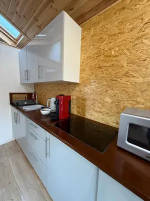 a kitchen with white cabinets and a microwave at Studio with a View in Onich