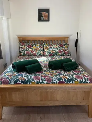a bed with two green pillows on it at Studio with a View in Onich