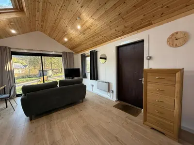 a living room with a couch and a clock on the wall at Studio with a View in Onich