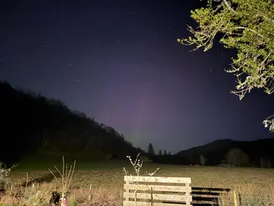 a starry night with a wooden bench in a field at Studio with a View in Onich