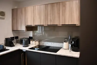 a kitchen with wooden cabinets and a counter top at Barassie Bay View apartment in Troon