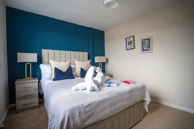 a stuffed animal sitting on a bed in a bedroom at 2 BDR House By Caledonia Luxe Stays Short Lets & Serviced Accommodation Bathgate in Bathgate