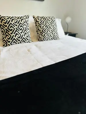 a bed with two pillows on top of it at Modern Economy Glasgow Apartment with King bed in Glasgow