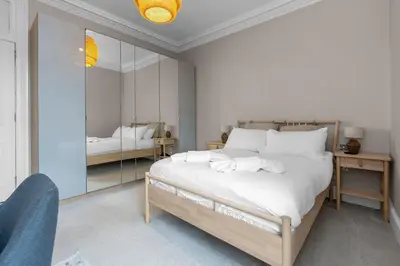 a bedroom with a large bed and a mirror at GuestReady - Charming home in Edinburgh in Edinburgh