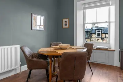 a dining room with a table and chairs and a window at GuestReady - Charming home in Edinburgh in Edinburgh